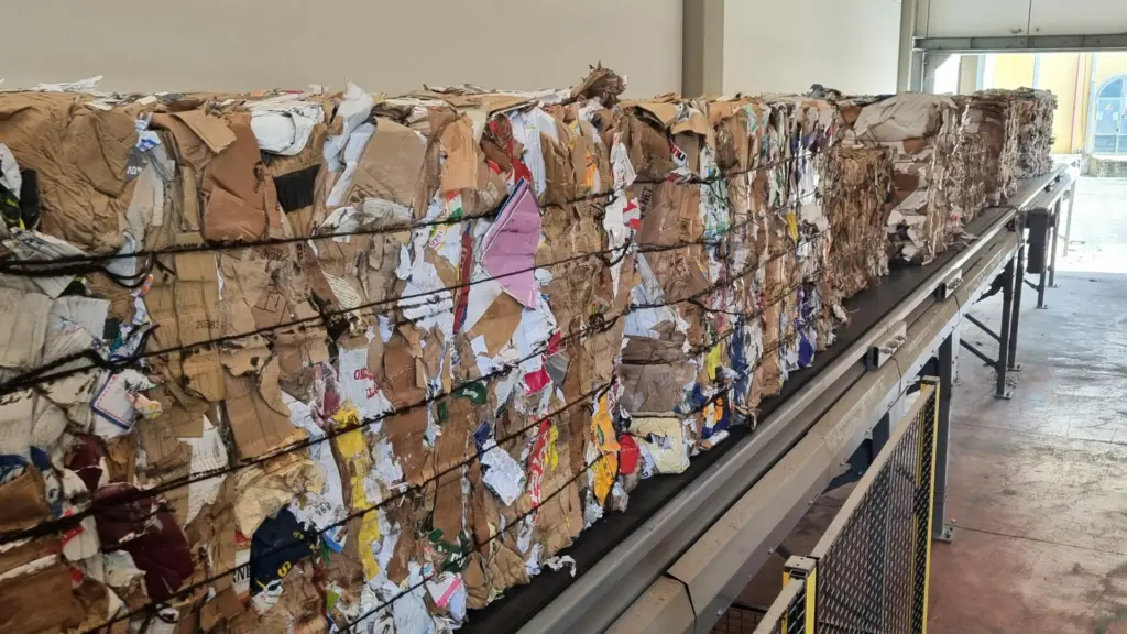 On Image: Paper bales´ storage on feeding conveyor of a dewiring machine